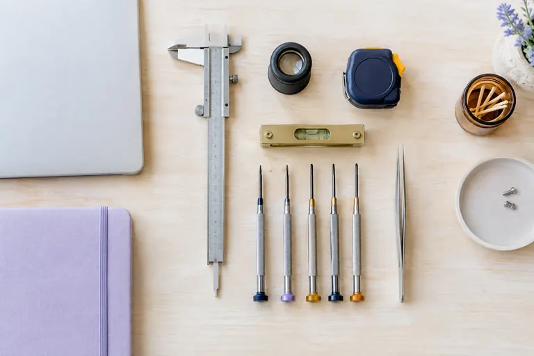 Outils de précision alignés sur un établi clair près d'un ordinateur portable fermé